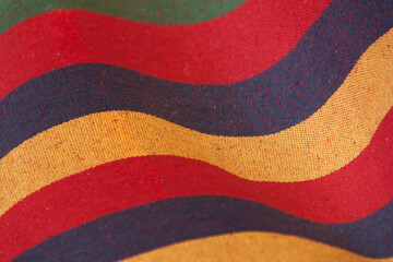 Multicolored wavy striped fabric texture on background.