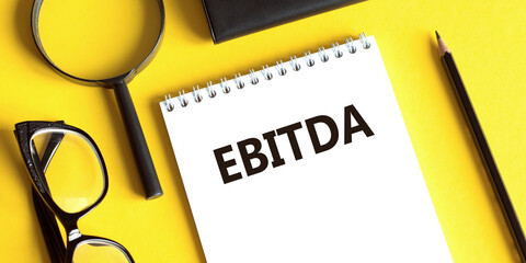 EBITDA - Earnings Before Interest, Taxes, Depreciation and Amortization acronym text on notepad,...