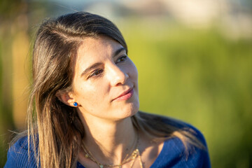 Close up view of a woman outdoors in nature on a sunny day.