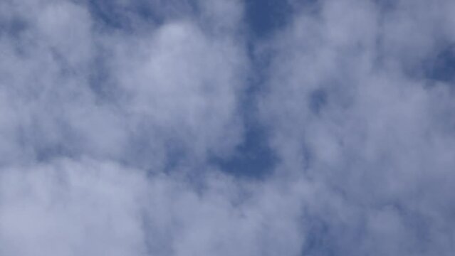 Défilement horizontal en accéléré de nuages blancs dans un ciel bleu