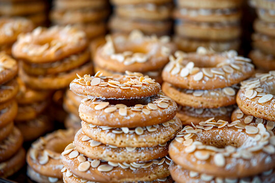 Close-up shot of a pile of round cookies sprinkled with almonds, focusing on the details and textures
