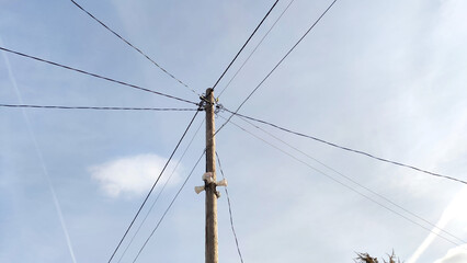 Old pole with wires against the sky. Electric transmission line. Eco-friendly energy