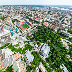 Aerial city view with crossroads and roads, houses, buildings, parks and parking lots, bridges. Helicopter drone shot. Wide Panoramic image.