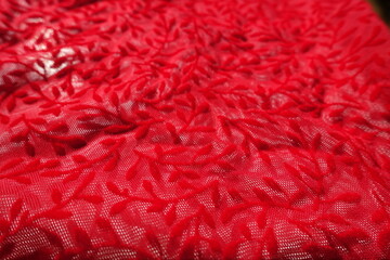 Macro of semi-transparent scarlet red burnout velvet fabric