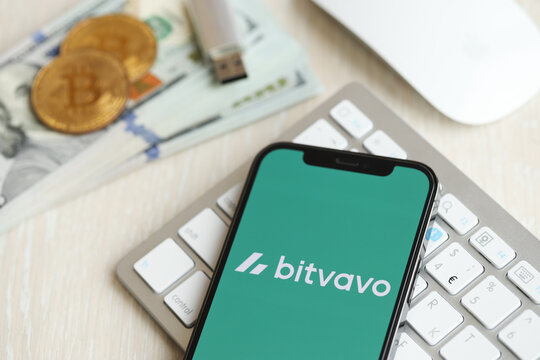 KYIV, UKRAINE - MARCH 15, 2024 Bitvavo logo on iPhone display screen on white keyboard with money and bitcoins. Cryptocurrency exchange portal