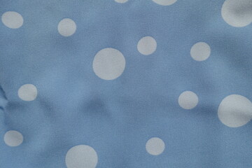 Top view of light blue rayon fabric with polka dot pattern