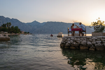 Couple is having a private event dinner on a tropical beach during sunset time