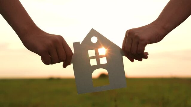 hands holding paper house, window sunset ray, happy family mortgage build new house, home buying guide, housing market trends, mortgage rates today, moving house checklist, new construction homes