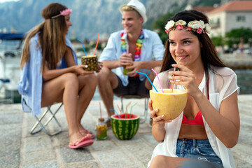 Trendy group of friends drinking cocktails at party. Young people having fun on luxury resort.