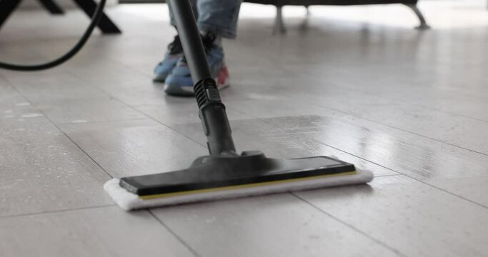 Housewife cleaning laminate floor with steam mop closeup 4k movie slow motion. Cleaning of apartments and offices concept