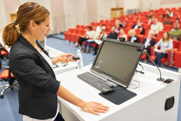 Speaker giving presentation during conference in auditorium