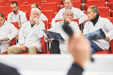 Doctors with x-ray sitting in audience during medical conference