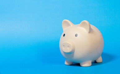 Cream color piggy bank on blue background