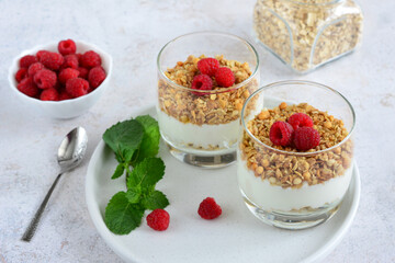 sugarfree dessert with yogurt, granola and raspberries in drinking glass