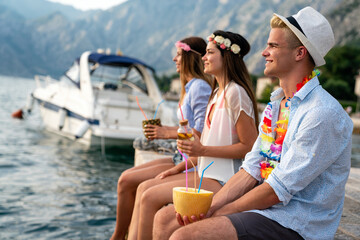 Multicultural trendy young people having fun drinking cocktails at beach party