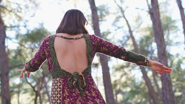 Concept of balance, harmony and health. Portrait of a young beautiful dancer, among natural landscapes. A young and beautiful girl dances and sings in the forest among the trees. improvisation.
