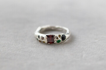 Silver ring with natural gemstones on a gray background. Elegant and sophisticated, perfect for special occasions.