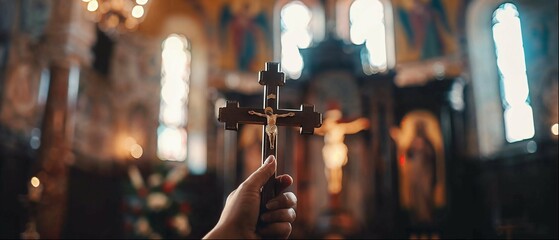 Devout moment captured with a hand holding a cross during catholic mass in a church - obrazy, fototapety, plakaty
