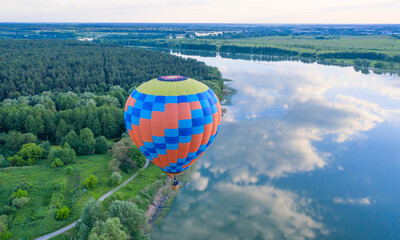 Elevated Tranquility: Balloon Soaring Above the Serene Waters - 773934487