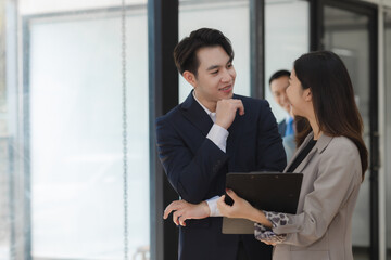 A group of employees happily work together in the office while discussing work that was completed...