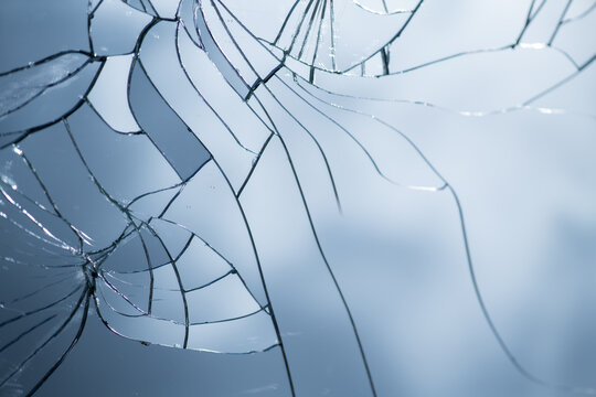 background of cracked mirror with broken glass shards reflecting the blue sky