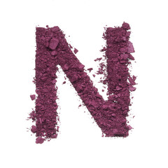Stencil capital letter N made by burgundy crushed eye shadow or broken powder isolated on white background.