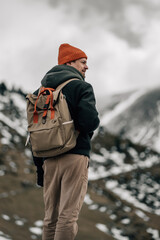 Rugged Hiker Facing the Wild, Snowy Mountain Terrain
