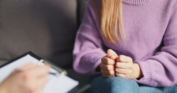 Person in therapy session with psychologist. Close-up of anxious hands