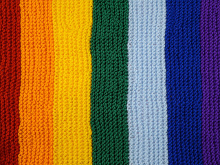 Part of wool hand-knitted scarf in rainbow colors, background
