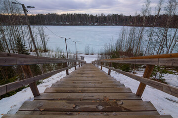 Fototapeta na wymiar Wooden trail in park in winter. Joutseno, Finland