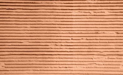 Abstract geometric background with 3D stripes of the concrete in peach fuzz trendy color
