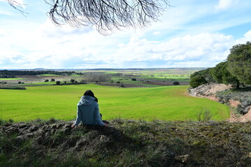 Fototapeta na wymiar Woman sitting contemplating the landscape