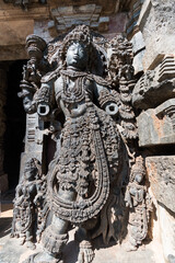 An ornate sculpture of a Dwarapala (gatekeeper) at the entrance to the ancient Hoysaleshwara temple complex in Halebidu in Karnataka.