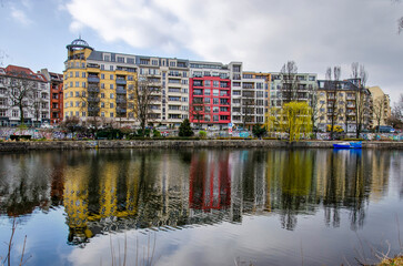 Fototapeta na wymiar Berlin, Germany, March 6, 2024: apartment buildings in Charlottenburg neighbourhood reflecting in the river Spree