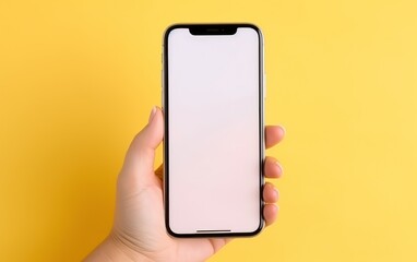 Mockup of hand holding cell phone with blank screen on yellow background