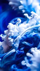Elegant swirls of blue and white ink creating abstract shapes in fluid motion