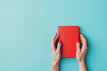 Woman hands holding book with blank red cover over light blue background. Education, back to school, self-learning, book swap, sharing, bookcrossing concept