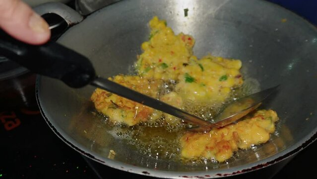 The process of cooking corn cakes by frying until golden brown