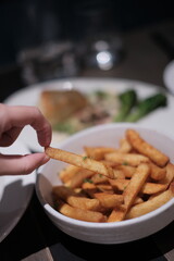 French fries on restaurant table with hand, motion 