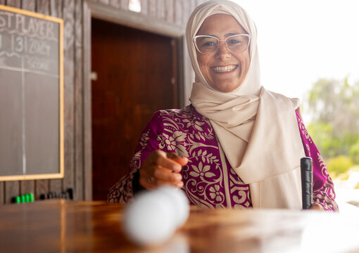 Joyful muslim woman enjoying a game of mini golf