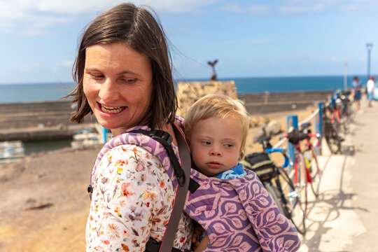 Loving Mother Holding Child with Down Syndrome by the Sea