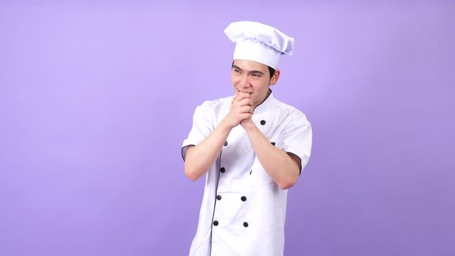 Young Asian male chef on purple background