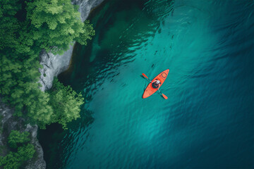 Aerial view of a kayak in the blue water. Kayaking top view. Kayaker in the yellow kayak paddling on the sea