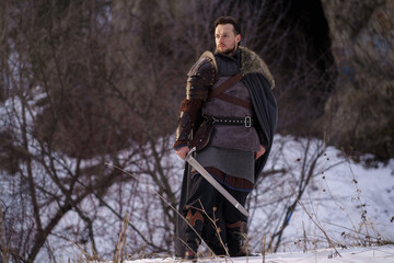 Medieval knight with sword in armor as style Game of Thrones in winter forest - 773975094