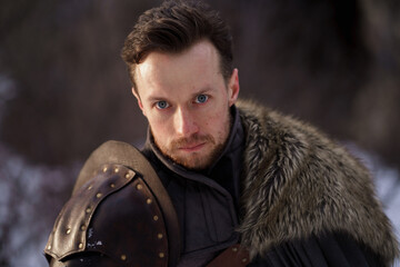 Prtrait medieval knight with sword in armor as style Game of Thrones in winter forest - 773975206