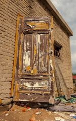 Stary budynek z cegły - drzwi z łuszczącą się farbą, remont. Zabytkowy budynek z białej...