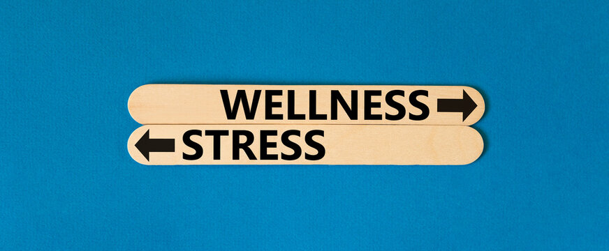 Wellness or stress symbol. Concept word Wellness or Stress on beautiful wooden stick. Beautiful blue table blue background. Healthy and Wellness or stress concept. Copy space.