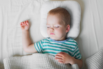 Toddler boy sleeping close-up on bed. Health care concept