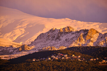 Views of Sierra Nevada from Granada during the golden hour at sunset with the peaks full of snow. - obrazy, fototapety, plakaty