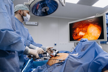 A group of medical surgeons in the operating room during an operation. A patient on the operating...